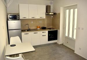 una pequeña cocina con armarios blancos y una mesa en Apartment Bellevue en Korčula