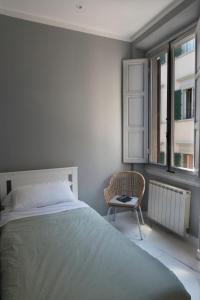 a bedroom with a bed and a chair and a window at Sun Frediano Suites Florence in Florence
