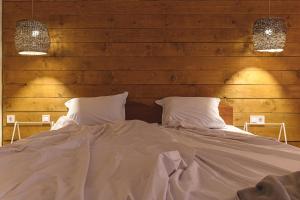 a bed with two pillows in a room with wooden walls at The Monkee Studios in Sveti Vlas