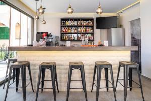 a bar with four stools in front of a counter at Dionisos Apts Gouvia by Estia in Corfu