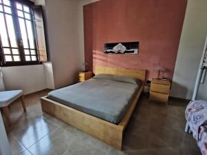 een slaapkamer met een bed, een tafel en een raam bij Le Case del Parco in Peschici