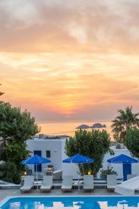 a view of a pool with chairs and umbrellas at Fragoulis Village in Parasporos
