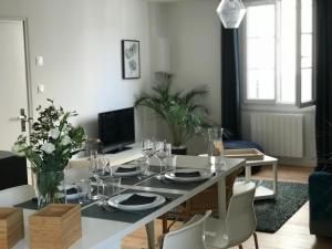 uma sala de estar com uma mesa de jantar com cadeiras em Appartement au coeur du quartier historique em Vannes