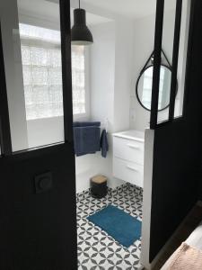 uma casa de banho com uma porta preta e um tapete azul em Appartement au coeur du quartier historique em Vannes