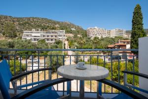 a table on a balcony with a view of a city at Dolfin in Tolo