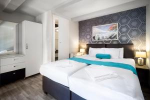 a bedroom with a large white bed and a tv at Hotel Mika Downtown in Budapest