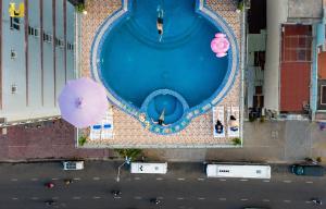 an overhead view of a pool with an umbrella at Merry Land Hotel Da Nang in Danang