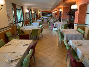 a dining room with tables and chairs with white tablecloths at La Carrozza d'Oro in Montefiascone