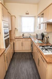 a kitchen with a sink and a stove top oven at Babbacombe Apartments in Torquay