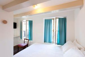 Schlafzimmer mit einem weißen Bett und blauen Vorhängen in der Unterkunft Hotel The Exchange in Amsterdam