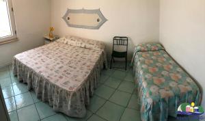 ポンツァにあるMagi - Appartamento Lunaのベッドルーム1室(ベッド2台、椅子付)
