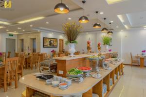 a long table with food on it in a restaurant at Merry Land Hotel Da Nang in Danang