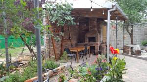 un patio con tavolo e sedie in legno in giardino di Binuli House a Kobuleti