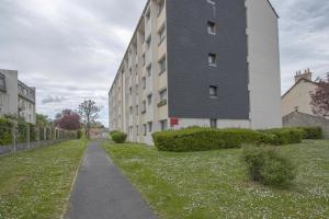a building on a grass field next to a building at APPARTEMENT MODERNE A CAEN POUR 4 PERSONNES in Caen