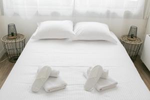 Una cama con sábanas blancas y zapatos blancos. en APPARTEMENT MODERNE A CAEN POUR 4 PERSONNES, en Caen