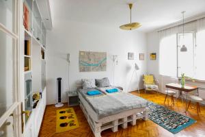 a bedroom with a bed and a table in it at Bright Lights, Big City Studio in Budapest