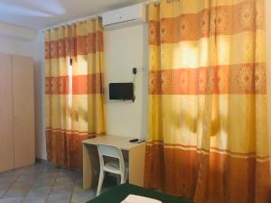 聖特雷莎加盧拉的住宿－Albergo Villamarina，配有书桌和窗帘的房间
