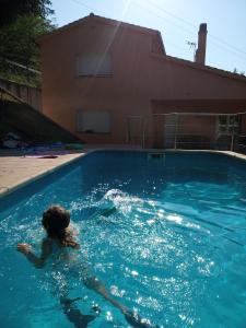 een vrouw die zwemt in een zwembad bij CAN MENCIÓ - Les Costes in Santa Pau