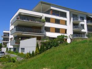 een wit appartementencomplex bovenop een heuvel bij Baselblick in Lörrach