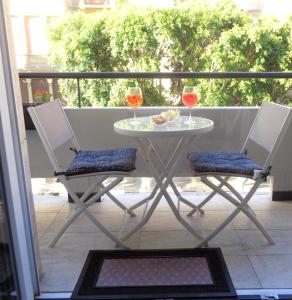 d'une table et de deux chaises avec des verres à vin sur le balcon. dans l'établissement Chloe's Rooms, à Cagliari
