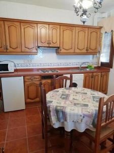 una cucina con tavolo e una cucina con armadietti in legno di Apartamento Ruta de las Nieves a Capileira