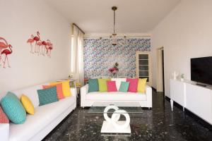 sala de estar con 2 sofás blancos y TV en Flamingo & Cactus by the Sea, en Levanto