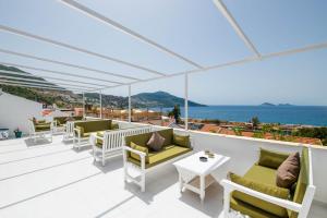 a patio with chairs and tables and a view of the ocean at Old Kalamaki Pansiyon in Kalkan