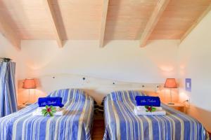 two beds in a room with blue and white stripes at Villa Boubouki in Évyiros