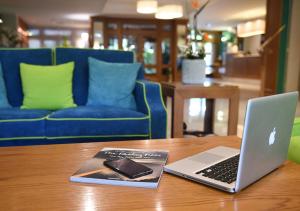 un ordenador portátil sentado en una mesa con un libro en Iseo Lago Hotel, en Iseo