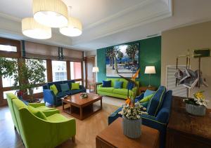 Iseo Lago Hotel في إيزِيو: غرفة معيشة ذات أثاث أزرق وأخضر