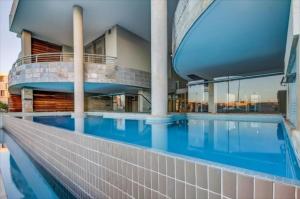 a swimming pool in front of a building at 706 Canal Quays in Cape Town