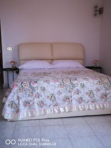 Una cama con colcha floral encima. en Villa Galilei Rooms, en Pisa