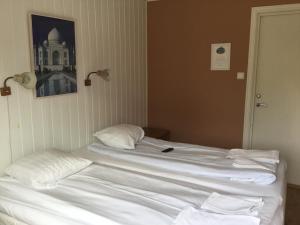a bed with white sheets and pillows in a room at Solö in Byxelkrok