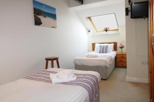 a room with two beds and a window at Houndapitt Cottages in Bude