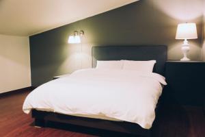 una camera con un grande letto bianco e due lampade di GONGGAN Residence Hotel a Geoje