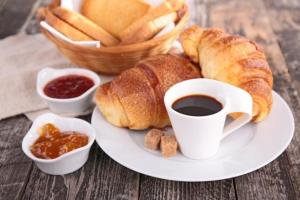 a plate of food with croissants and a cup of coffee at Albergo Villamarina in Santa Teresa Gallura