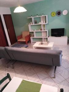 ein Wohnzimmer mit einem Sofa und einem Tisch in der Unterkunft Apartments L&M in Rogoznica