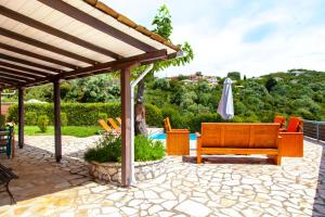 a patio with a bench and an umbrella at Villa Melody Private Pool Villa with Mountain Views in Fternón