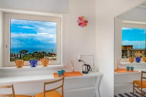 a dining room with a window with chairs and vases at 3 Suites View in Sorrento