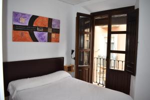 
a bedroom with a bed and a window at Pension Castil in Granada
