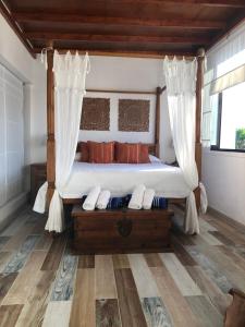 a bedroom with a canopy bed and a wooden floor at La Aurora in Antigua