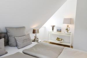 a white bedroom with a bed and a table at Seeblick-Norddeich in Norddeich
