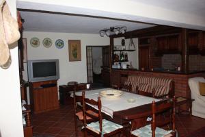 a dining room with a table and chairs and a television at Villa Orlando in Bova Marina
