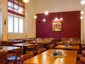 uma sala de jantar com mesas e cadeiras de madeira em Cloister Inn Hotel em Praga