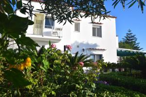 a white house with flowers in front of it at Oasi di Villa Damecuta in Anacapri
