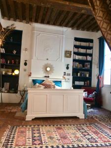 - une chambre avec un grand lit blanc dans l'établissement Le Boudoir d'artiste, à Semur-en-Auxois