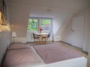 a bedroom with a bed and a table with chairs at Sonniges Häuschen mit Garten in Braunschweig