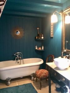 La salle de bains est pourvue d'une baignoire et d'un lavabo. dans l'établissement Le Boudoir d'artiste, à Semur-en-Auxois
