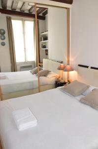 a bedroom with two beds and a mirror at Latin Quarter - Saint Michel Unit 004 in Paris