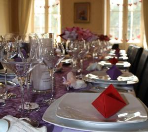 stół z kieliszkami do wina i talerz z czerwoną serwetką w obiekcie La Maison Chaudenay w mieście Chaudenay